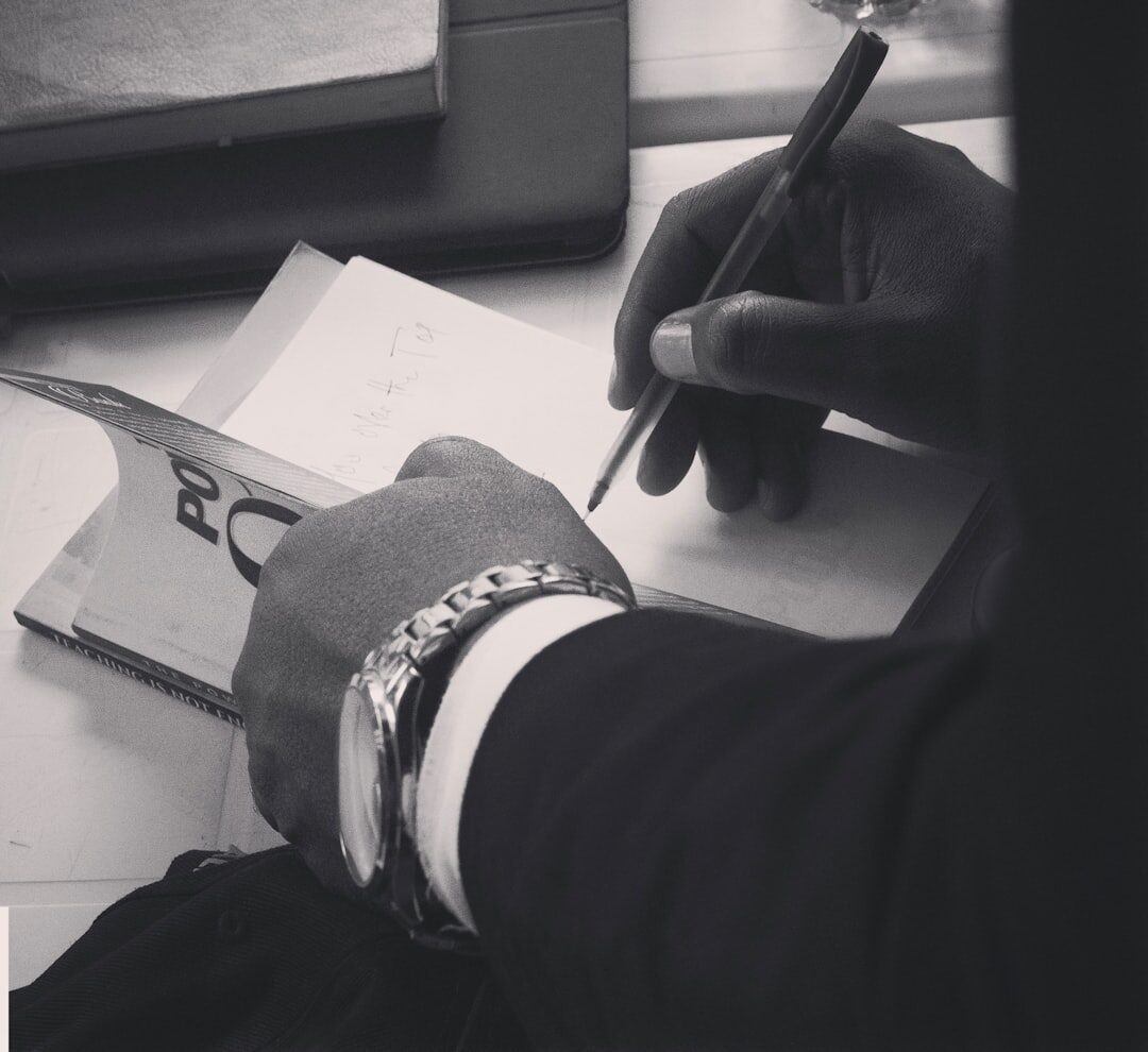 African journalist writing notes at a desk, focused expression